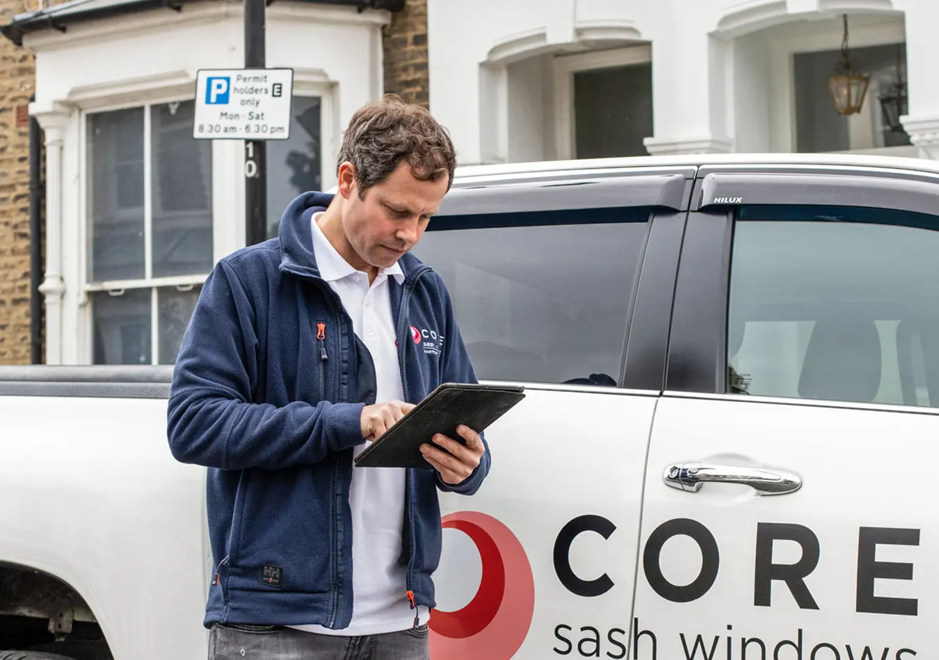 surveyor using an ipad in front of a truck